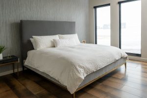 Master bedroom with floor to ceiling windows and hardwood floors