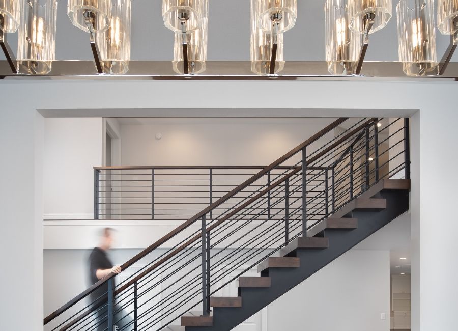 Staircase with light fixtures in a custom home remodel